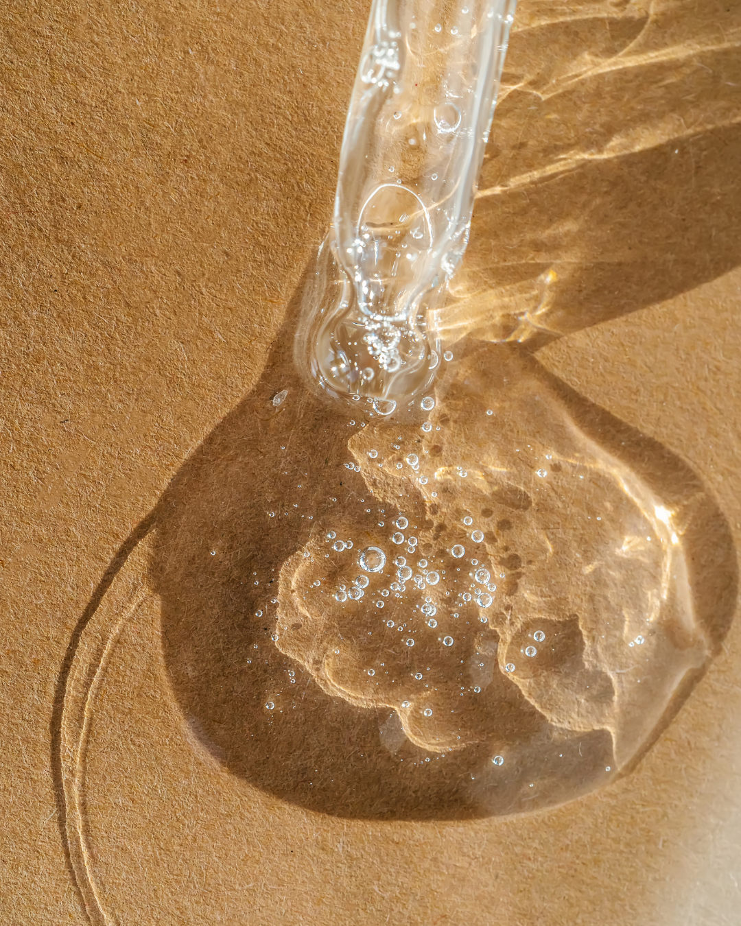 Clear gel or serum with bubbles on a brown surface